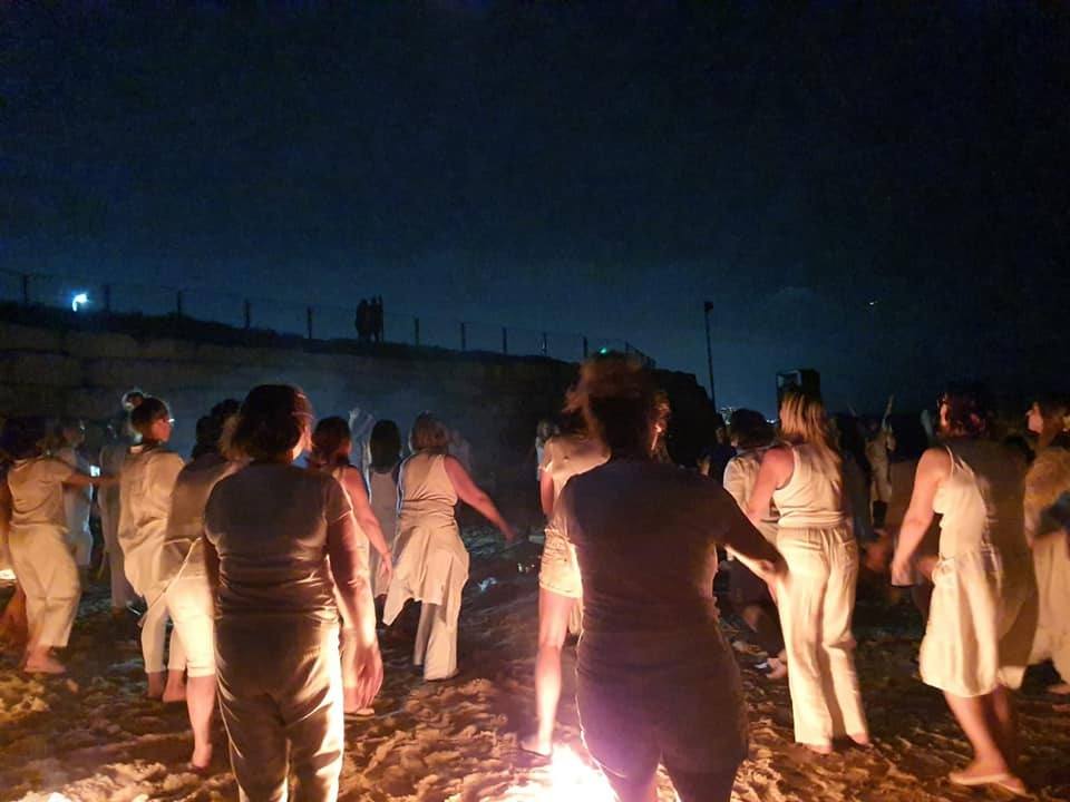 נשים בלבן סביב המדורה בלילה בטקס התשליך
